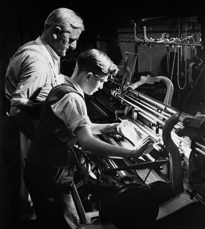Een meester traint een jonge leerling in machinaal breien, Lyle en Scott, Hawick door Unbekannt