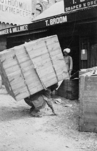Een drager tilt een zware last, Chakrata, India, 1917 door Unbekannt