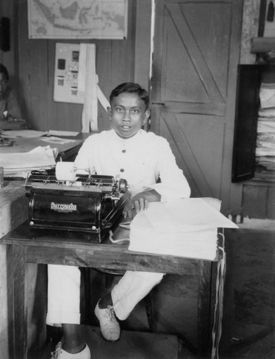 Een jonge man zittend aan een typemachine, Indonesië door Unbekannt