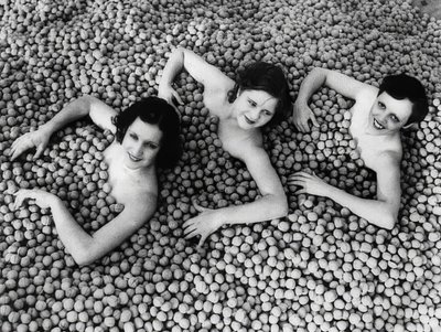 Drie jonge vrouwen baden in een zee van walnoten door Unbekannt