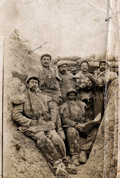 Eerste Wereldoorlog (1914-1918): Harige soldaten in winterkleding in een loopgraaf in 1916-1917. Ze dragen schapenvachten en een gasmasker. door Unbekannt