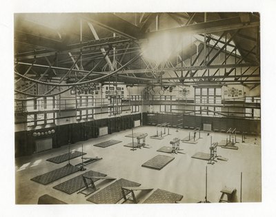 Horizontale foto van het interieur van een grote sportschool. Apparatuur en matten liggen verspreid over de vloer door Unbekannt