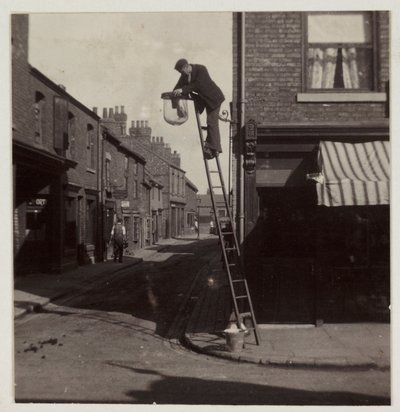 Man die een gaslantaarn schoonmaakt, ca. 1905 door Unbekannt