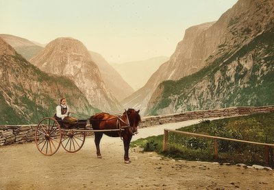 Noors boerenmeisje op een paardenwagen. Circa 1900. Photochrom. Fotografie van Photoglob / Zurich door Unbekannt