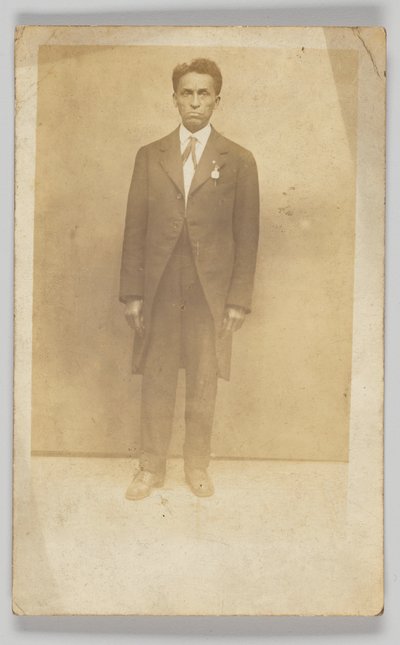 Fotografische ansichtkaart van een man in een pak door Unbekannt