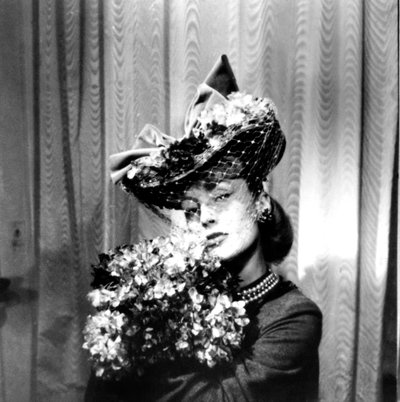Vrouw met een hoed met een sluier, die een boeket bloemen vasthoudt, Parijs, 1943 door Unbekannt