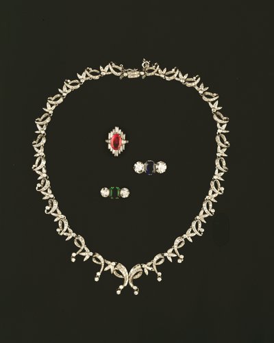 Art Deco ketting met rol- en bladontwerp; robijn- en diamantbaguettring; saffier- en diamantdriesteenring; smaragd- en diamantdriesteenring door Unbekannt Unbekannt