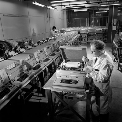 Een rij voltooide Envoy telexmachines wordt gecontroleerd door Unbekannt