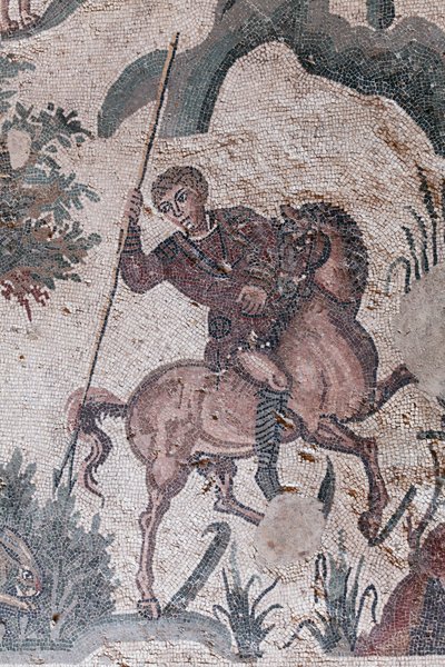 Detail van het mozaïek van de kleine jacht. Een jager staat op het punt een haas te spietsen. 3e - 4e eeuw. Romeinse Villa van de Casale, Sicilië. UNESCO-site. door William M. Timlin