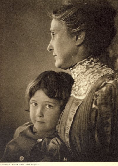 Halflang portret van een kind teder omhelsd door een oudere dame. De vrouw poseert met haar gezicht in profiel, terwijl ze de borst van de kleine jongen vasthoudt. Hij heeft een levendige en brutale blik, gericht op de camera door Unbekannter Künstler