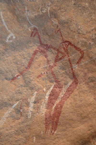 Rotstekeningen, Prehistorie: Rotsschildering van twee langgerekte figuren in een versierd onderkomen in de Uweinat-bergen, Soedan. Fotografie door Unbekannt