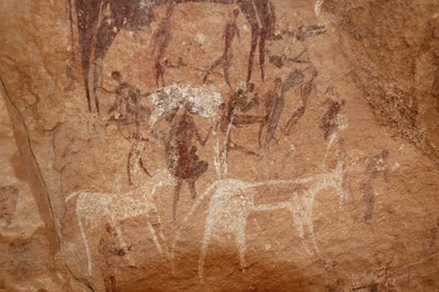 Rotstekeningen, Prehistorie: Rotsschildering van personages en koeien in een versierd onderkomen in het Uweinat-massief, Soedan (Karkur-Talh of Karkur Talh). Periode van 8000 tot 3000 jaar v.Chr. Fotografie door Unbekannt