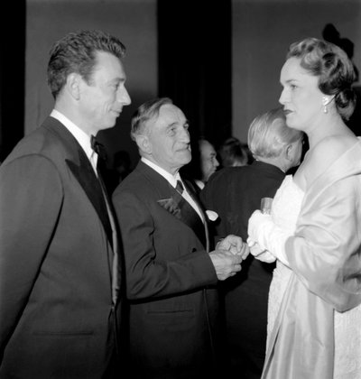 De filmcriticus Georges Sadoul met de acteur en popzanger Yves Montand en de Begum Jeanne Andre van Aix les Bains in Cannes - 1954 door Unbekannt