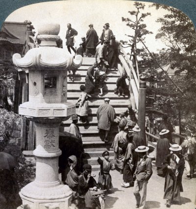 Gelovigen steken de halfronde brug over naar de Kameido-tempel, kijkend naar het noorden, Tokio, Japan door Underwood and Underwood
