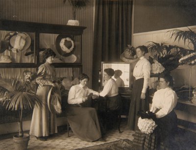Vijf dames in een hoedenwinkel door Unidentified
