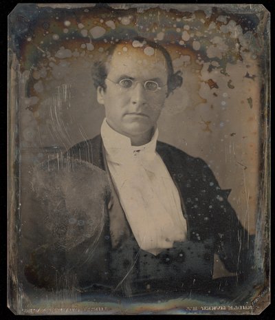 [Portret van een zittende man met een ovale bril met draadrand]. door Unknown artist