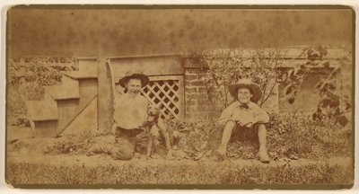 [Twee jongens zitten op de grond met een hond]. door Unknown artist