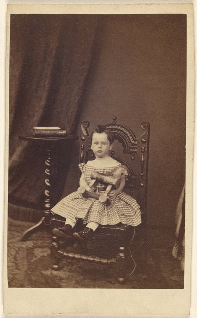 [Ongeïdentificeerd klein meisje dat een houten speelgoedpaard vasthoudt, zittend]. door Unknown artist