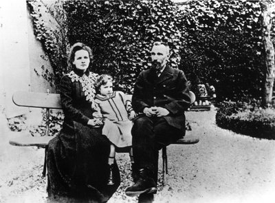 Pierre (1859-1906) en Marie Curie (1867-1934) zittend op een bankje in een tuin. door Unknown photographer