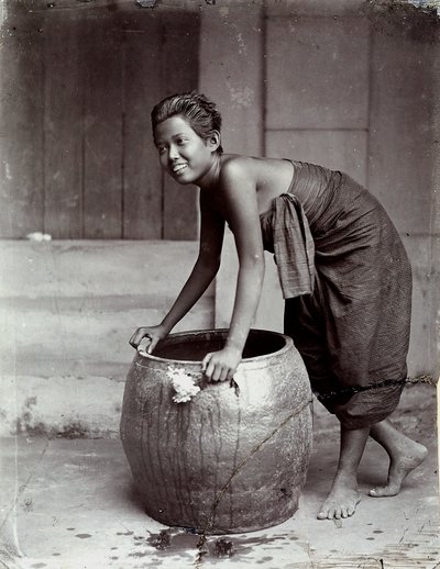 Jonge glimlachende Thaise vrouw, duwt een grote container door Unknown photographer