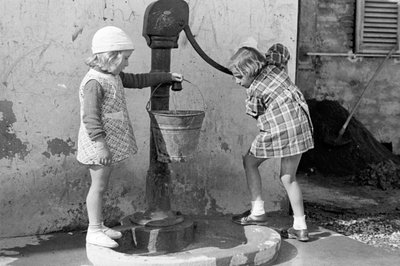 Kleine meisjes vullen een emmer water, 9 mei 1939 (z/w foto) door Vincenzo Balocchi