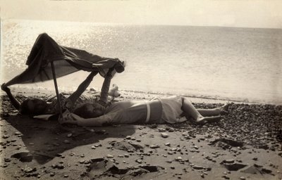 Twee vrouwen liggen aan zee in de schaduw van een handdoek. Briefkaart gestuurd door de fotograaf naar Vincenzo Balocchi door Vincenzo Balocchi