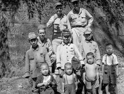 Amerikaanse soldaten met Japanse familie poseren samen na Japanse overgave door Volkmar Wentzel