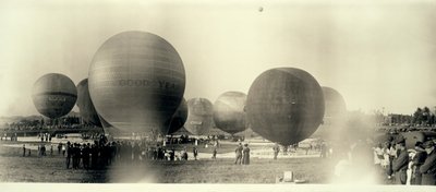 Heteluchtballonnen op een veld in Zuid-St. Louis klaar voor lancering; één is al in de lucht in de verte door W.C. Persons