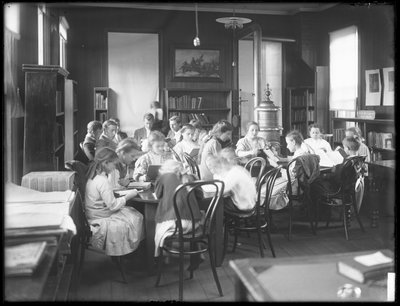 Kinderen lezen in de leeszaal van een niet-geïdentificeerde vestiging van de Queens Borough Public Library, ca. 1910 door William Davis Hassler