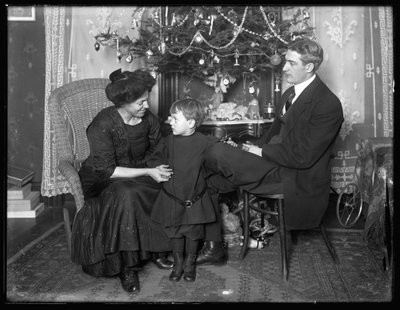 Dan Seymour en familie in informele pose, zittend onder een kerstboom, Kerstmis 1912 door William Davis Hassler