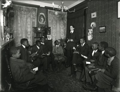 Evangelistencomitéles bij mevrouw Bostick, 72 West 99th Street, de heer Rockwood geeft les aan een groep jonge Afro-Amerikaanse mannen en jongens. 31 maart 1916 door William Davis Hassler