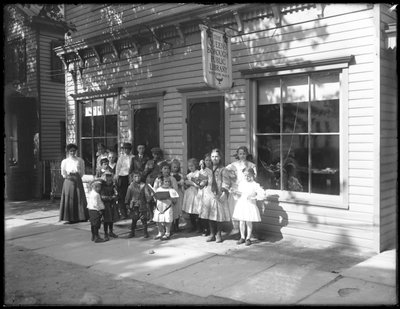 Groep kinderen geposeerd buiten het Whitestone-filiaal van de Queens Borough Public Library, ca. 1912 door William Davis Hassler