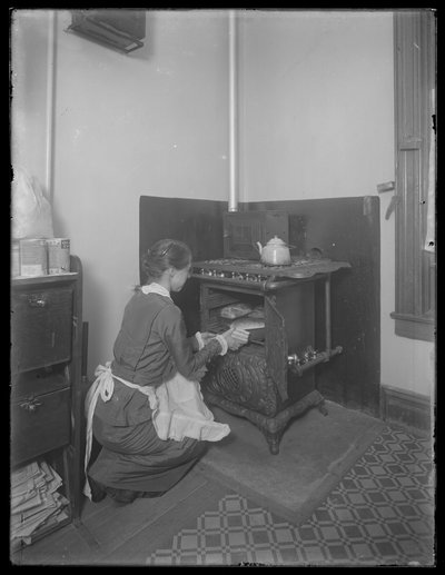 Miss Bates haalt brood uit de oven, ca. 1913 door William Davis Hassler