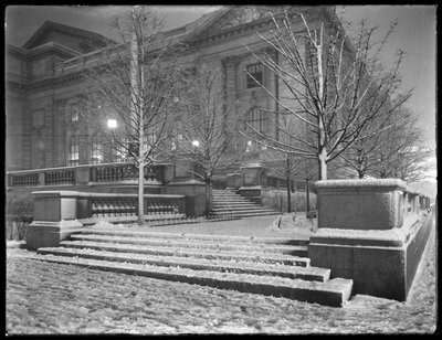 Nachtzicht van de noordoostelijke hoek van de trappen buiten het hoofdfiliaal van de New York Public Library in de sneeuw, 42nd Street en Fifth Avenue, New York City, 6 maart 1915 door William Davis Hassler