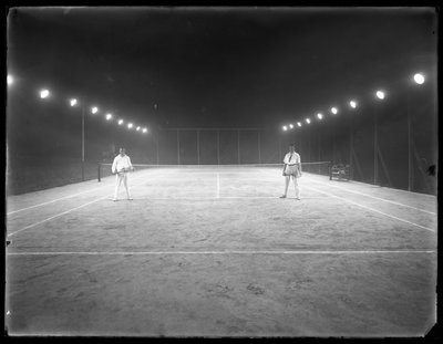 Twee jonge mannen op een onbekende klei tennisbaan 