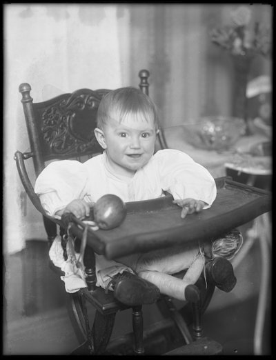 Onbekend kind zittend in een kinderstoel, 1915-16 door William Davis Hassler