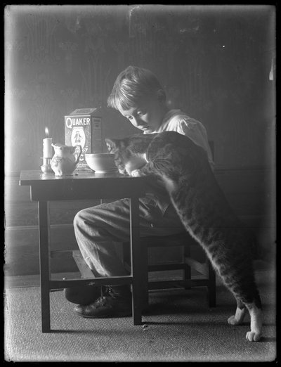 William Gray Hassler en Reddy de kat, eten Quaker gepofte rijst ontbijtgranen, c.1912 door William Davis Hassler