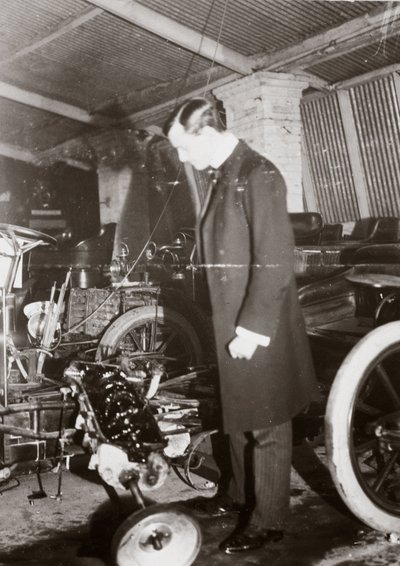 C S Rolls kijkt naar de motor van een auto in zijn garage, ca. 1900 door Ferdinand Georg Waldmuller