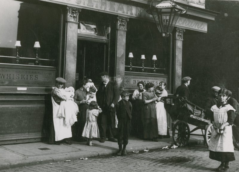 Mannen, vrouwen en kinderen buiten een Londense taverne door English Photographer