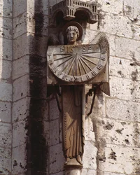 Gotische kunst: Representatie van de Engel op de Wijzerplaat. Beeldhouwwerk van de 20e eeuw naar een origineel uit de 16e eeuw bewaard in de crypte, zuidwesthoek van de Basiliek Notre Dame de Chartres (Eure et Loir)