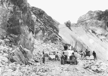 Gravers aan het werk in een marmergroeve in de Apuane Alpen, Toscane. Sommigen zitten op blokken marmer die al vierkant zijn gemaakt.