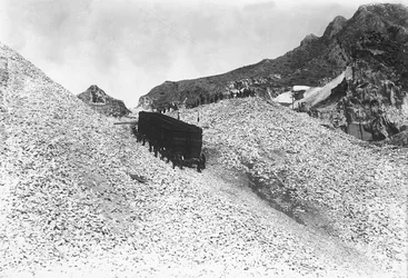 Transport van een enorm konvooi met marmer over een weg nabij een groeve in de Apuaanse Alpen, Toscane