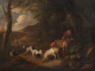 Jager met honden aan de rand van een bos