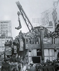 Houdini ontsnapt uit een dwangbuis terwijl hij aan een kraan in New York City hangt