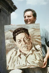 De Italiaanse schilder en schrijver Carlo Levi (1902-1975) met een van zijn werken in de hand, een portret van de vakbondsman Giuseppe di Vittorio (foto)
