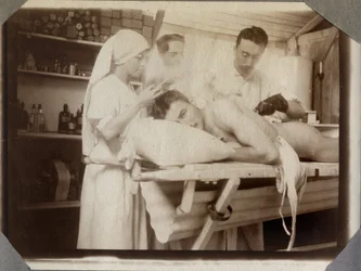 Eerste Wereldoorlog 1914-1918: artsen en verpleegkundige behandelen de wonden van een soldaat in de verbandkamer, kamp Couville in Manche, Laag-Normandië, Frankrijk. Anonieme foto, juli 1917. Privécollectie Stella.