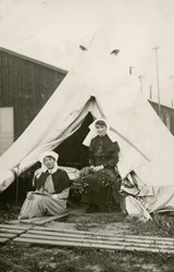 Zuster Eleanor Wibmer Jeffries en zuster Nellie Constance Morrice (rechts) buiten hun tent bij het 3e Australische Algemene Ziekenhuis, met bloemen geplukt aan de oever van de Somme, ca. juni 1917