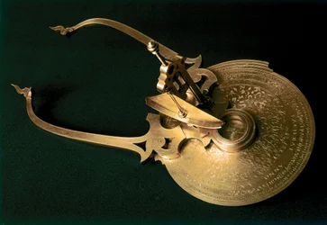 LANCI Baldassare: Nautisch kompas Het instrument bestaat uit een cirkelvormige plaat waarvan de rand een gradenschaal bevat die verdeeld is in acht sectoren van 45°, de namen van de winden en, op een vooruitstekend gedeelte, twee andere gegradueerde schale