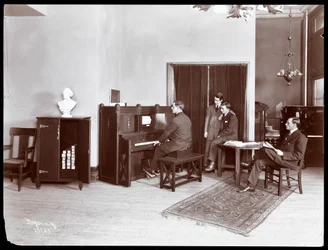 Vier mannen, een speelt op een H. Bruman Co. pianola, 1907