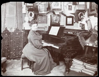 Madame Schumann Heink zittend aan een piano, 1906
